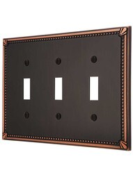 Imperial Bead Triple Toggle Switch Plate in Aged Bronze.